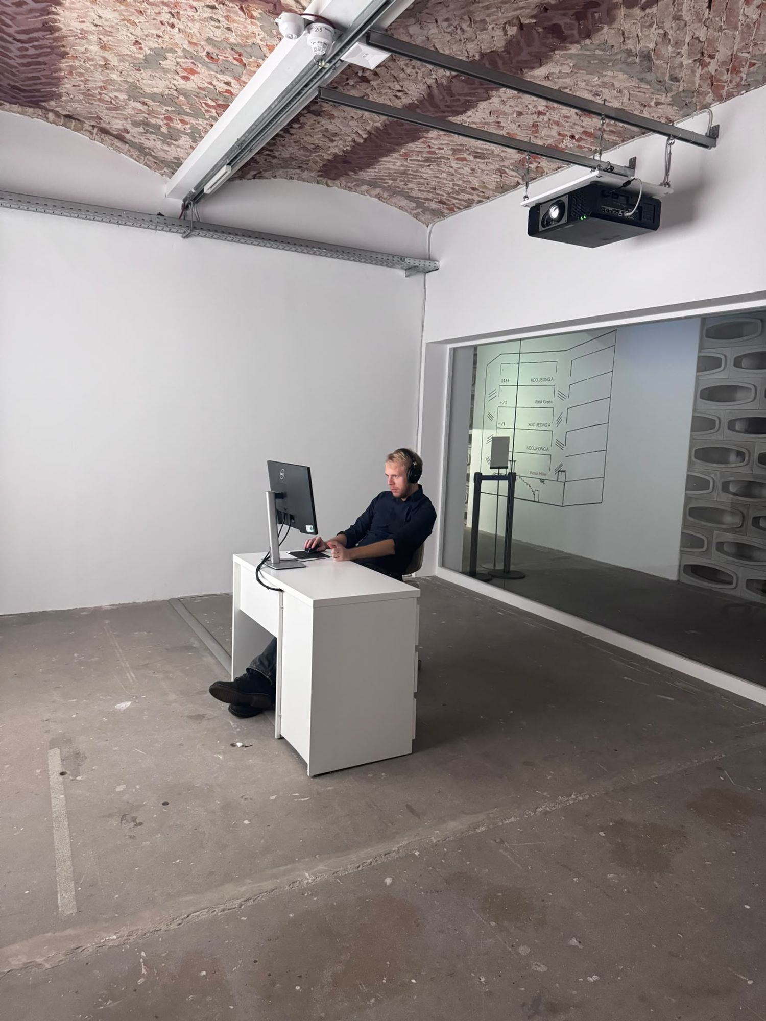 Susan Hiller, „Dream Screens“, 1996, als Schreibtisch mit Monitor und Kopfhörern im Gewölbe der KW, bevor die Projektion anspringt