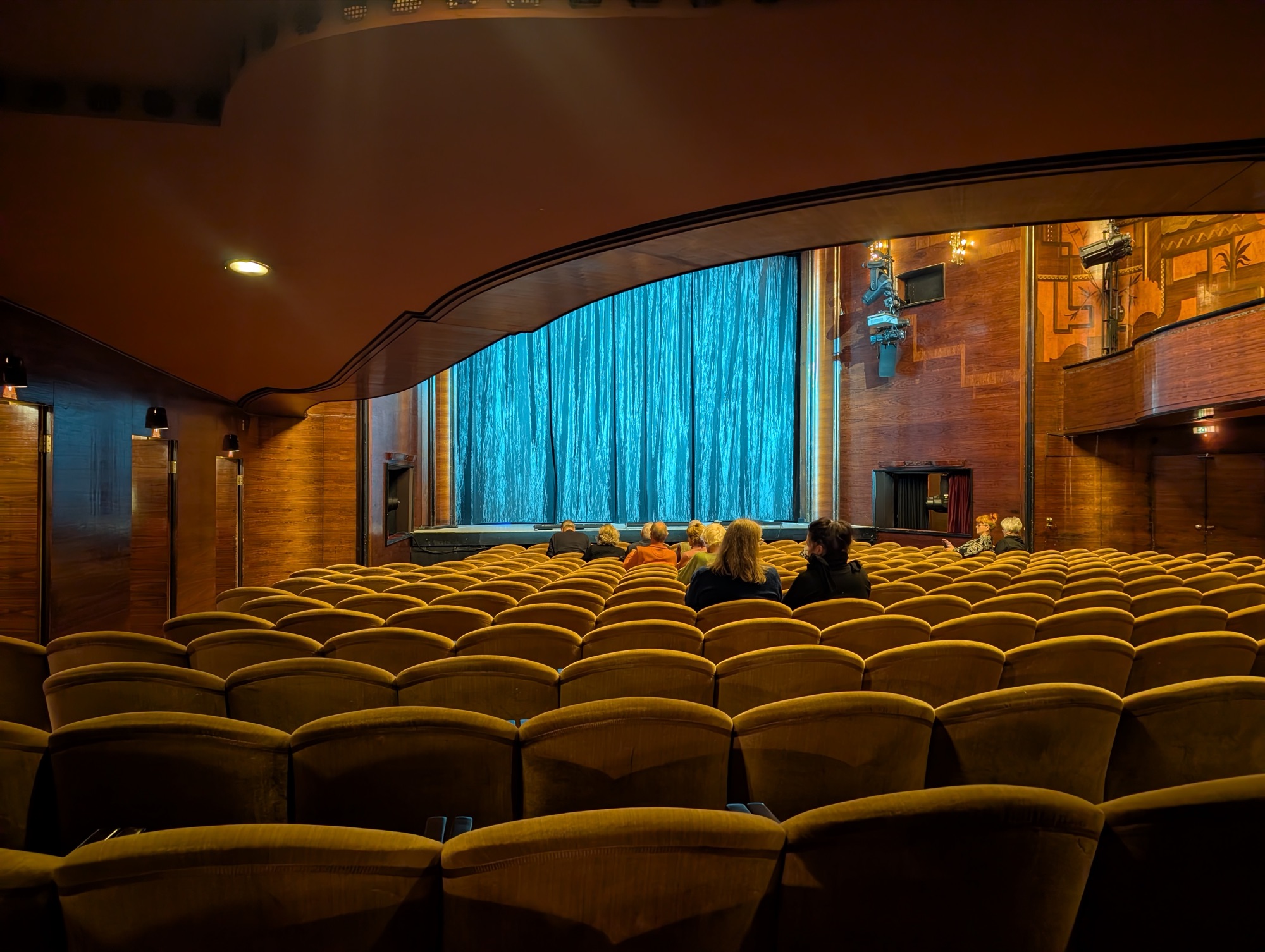 Der Große Saal des Renaissance-Theaters vor Beginn, mit blauem Vorhang und Samtsesseln